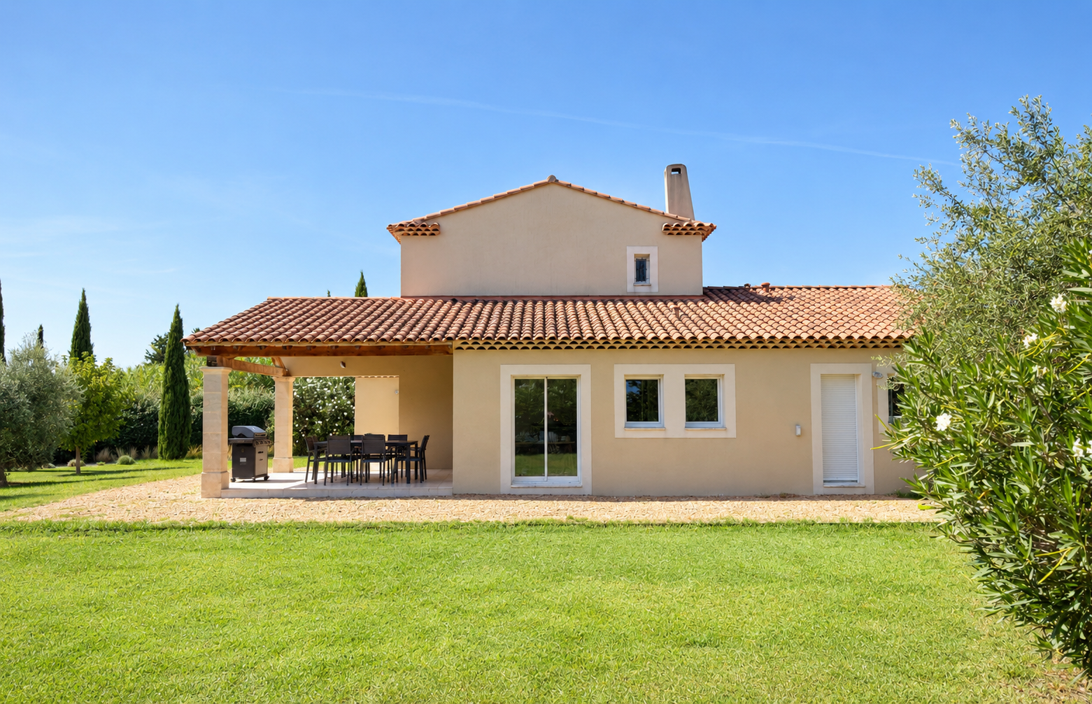 La façade est de la maison avec sa terrasse couverte et son jardin