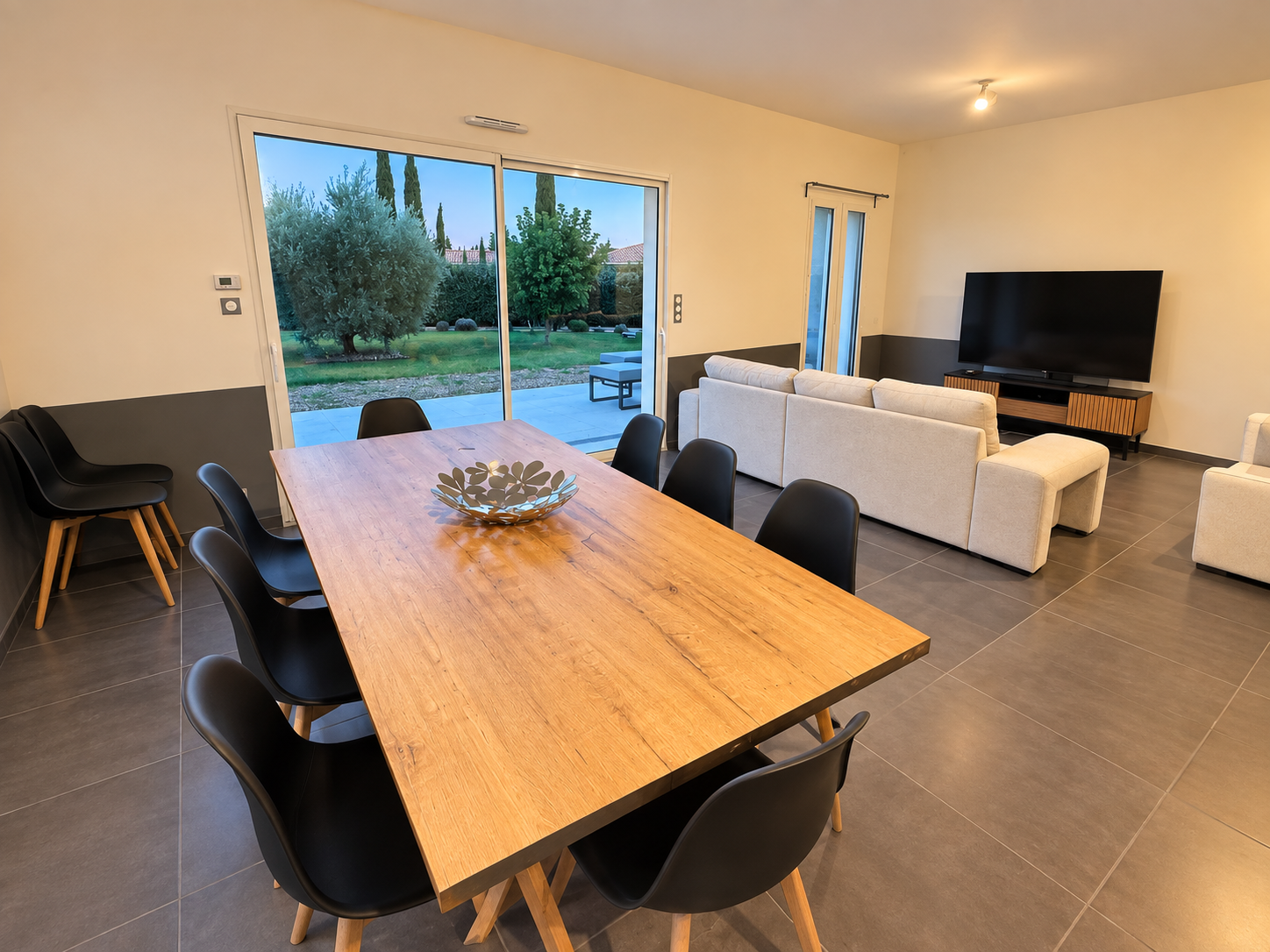Le salon et la salle à manger avec baie vitrée ouverte sur le jardin